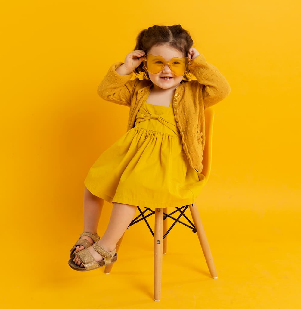 Criança feliz posando enquanto usava óculos de sol